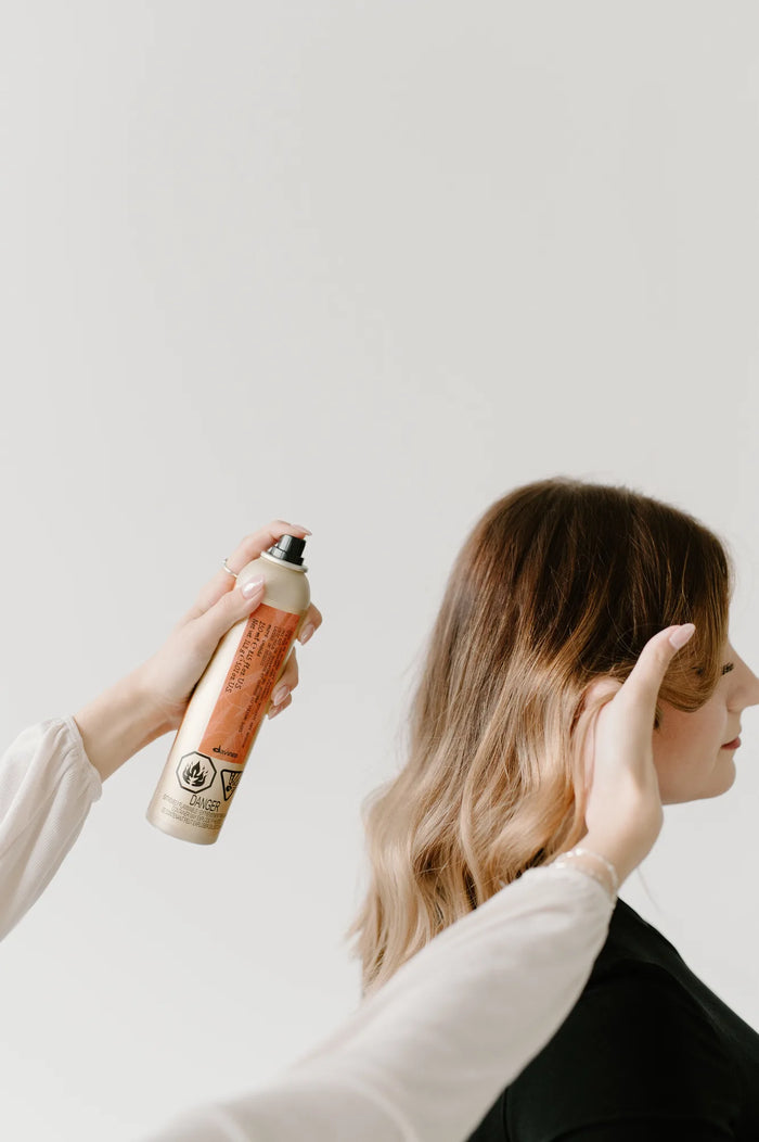 Moda Salon stylist spraying hair product onto soft waves