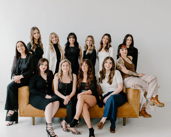 Group of women sitting on a couch against a white background