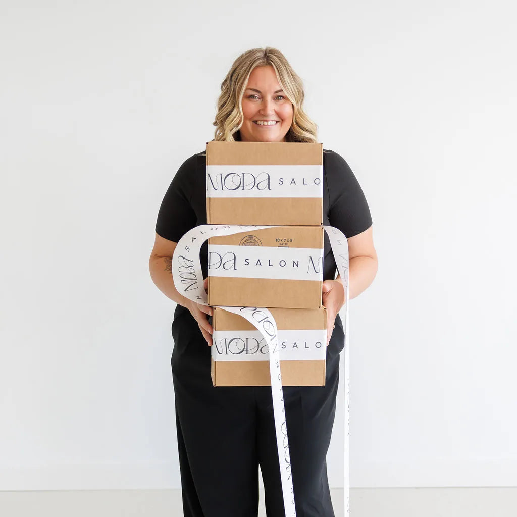 Person holding multiple boxes with 'Niko & Mari' branding against a white background