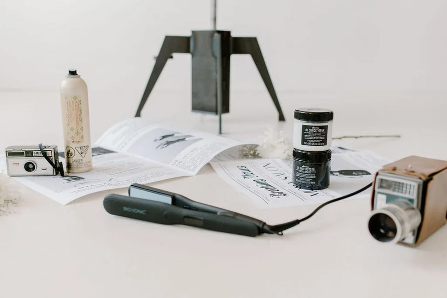 Moda Salon newspaper and styling tools flat lay