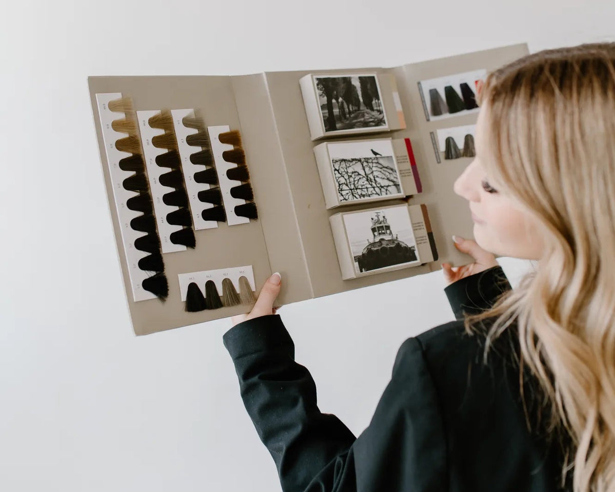 Person looking at a hair color chart against a plain background