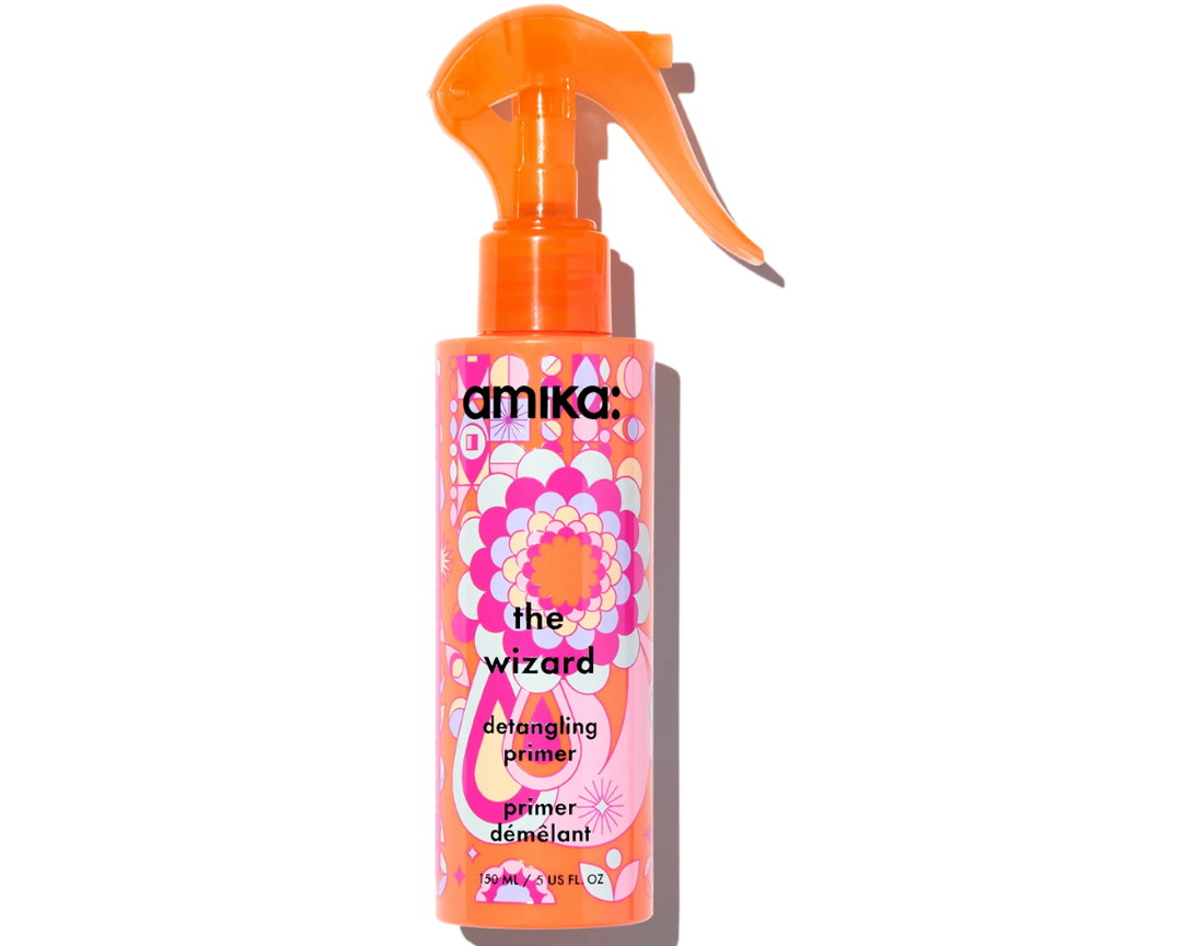 A bottle of Amika The Wizard Detangling Primer with colorful packaging.