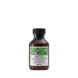 Bottle of Davines shampoo with a green label on a white background